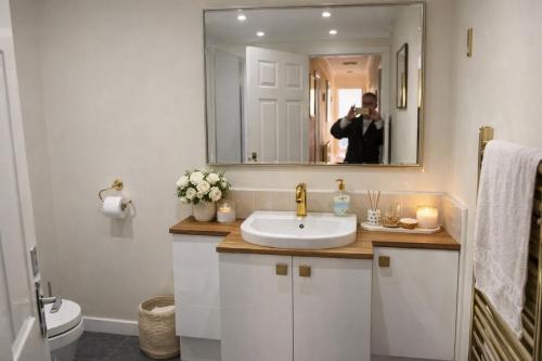 a person taking a picture of a bathroom with a sink at Crayford's Guest House in Aberdeen