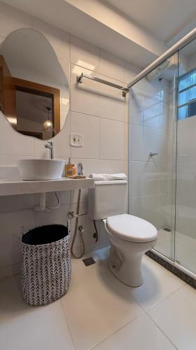a bathroom with a toilet and a sink and a shower at Pousada Mar da Vila in Cabo Frio