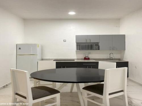 a kitchen with a table and chairs and a refrigerator at Villa Santa Julia in Oaxaca City