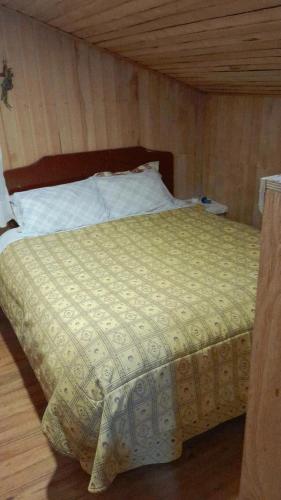 a bed in a room with a wooden ceiling at Casa Sureña en Ensenada in La Ensenada