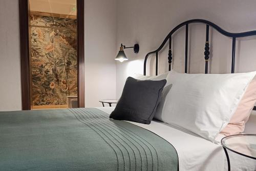 a bedroom with a bed with white pillows and a blanket at SUVAJ Rooms in Galatro