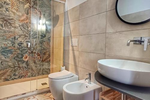 a bathroom with a toilet and a sink and a mirror at SUVAJ Rooms in Galatro