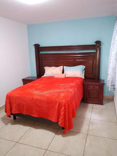 a bedroom with a bed with a red blanket at Mi Casa Elena in Morelia