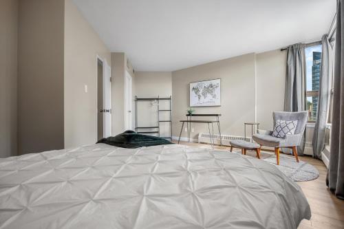 a bedroom with a large bed and a chair at Contemporary, cozy & easy to Rocky Mountains from Calgary ! in Calgary