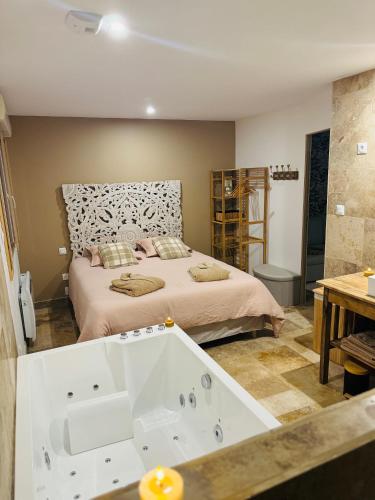 a bedroom with a bed and a bath tub at Gîte le Nid Dhugava in Hem-Hardinval