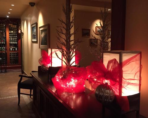 a room with a table with red lights and a vase at Hôtel Mingan in Sept-Îles