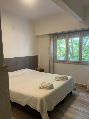 a bedroom with a bed with two towels on it at Cala Hotel MDP in Mar del Plata
