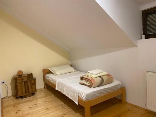 a small bedroom with a bed and a night stand at Apartman Jelena Sumarice in Divostin