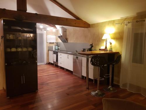 a kitchen with a black refrigerator and a wooden floor at Duplex T4 Sempre Endavant in Vernet-les-Bains