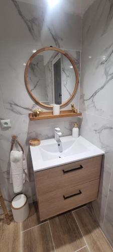 a bathroom with a sink and a mirror at Le Cocon des Vignes in Vidauban