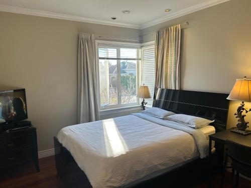 a bedroom with a large bed and a window at independent entrance cozy room with private bathroom close to YVR Richmond in Richmond