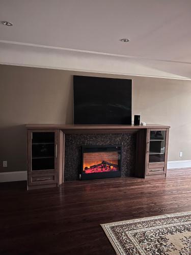 a fireplace in a living room with a flat screen tv at Vancouver Comfort Home 10 min to YVR airport, Close to Downtown in Vancouver