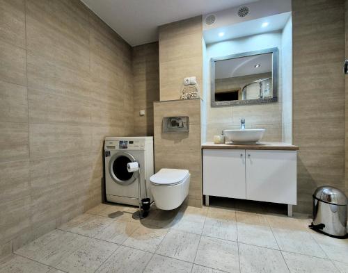 a bathroom with a toilet and a sink at TK Apartments Spiżowa in Wrocław