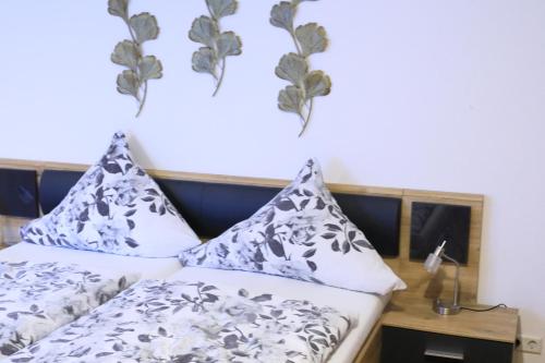 a bedroom with a bed with black and white pillows at Albglück in Gammertingen