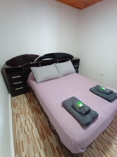 a bedroom with a bed with two towels on it at Cabaña Mailin in Uspallata