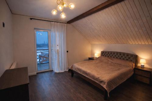 a bedroom with a bed and a large window at Корчин Гарден Шале in Korchin