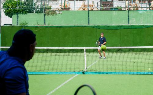 two people playing tennis on a tennis court at Villaggio Turistico Camping Cervino in Antey-Saint-André