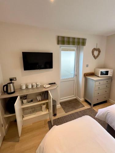 a bedroom with a bed and a television on a wall at Acorns in Hordle
