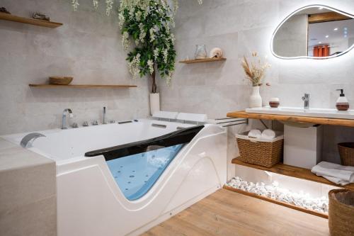 a bathtub with a swimming pool in a bathroom at L'Escapade Etoilée Rosheim in Rosheim