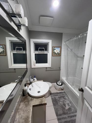 a bathroom with a sink and a toilet and a tub at Vancouver Comfort Home 10 min to YVR airport, Close to Downtown in Vancouver