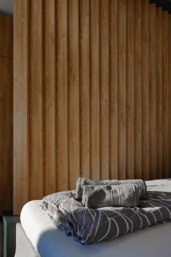 a bed in a room with a wooden wall at Eternity Apartment in Štúrovo