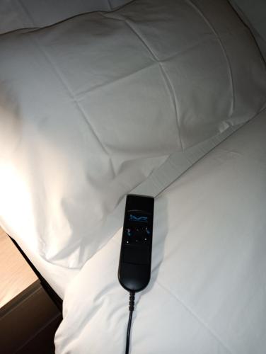 a remote control sitting on top of a bed at Le piscine in Villa Guardia