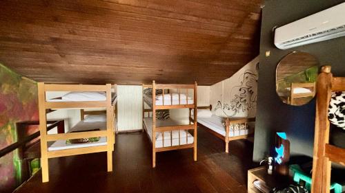 a room with three bunk beds in a house at Casa Lee Hostel in Paraty