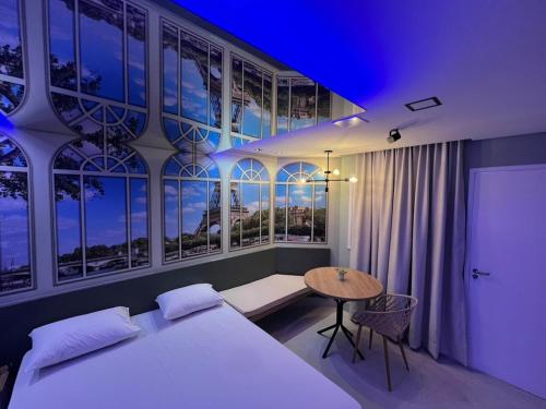 a bedroom with a bed and a table and windows at Motel Scala in Salvador