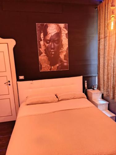 a bedroom with a bed with a painting above it at sweet home in Biella