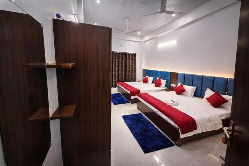 two beds in a room with red and blue pillows at Kharari Inn in Ayodhya