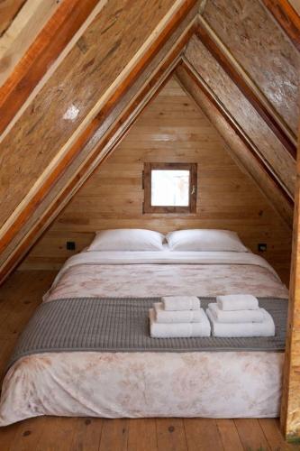 a bed in the middle of a room in a attic at Star Cottage in Bajina Bašta
