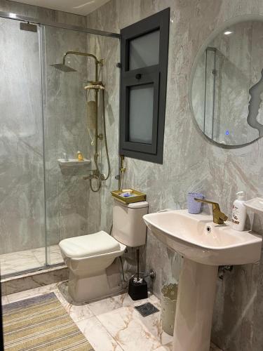 a bathroom with a toilet and a sink and a shower at Sun capital stylish apartment in ‘Ezbet `Abd el-Ḥamîd