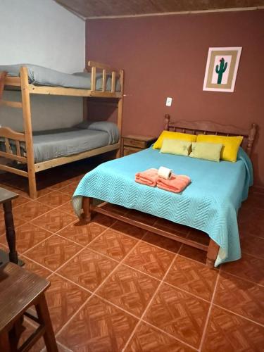 a bedroom with a bed with two bunk beds at Posada LO DE ELIAS in Tilcara