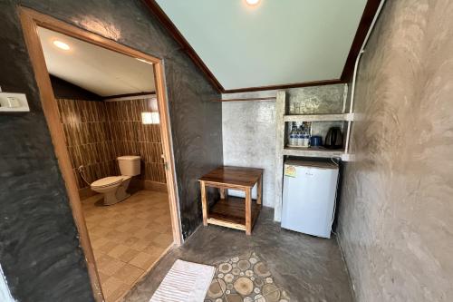 a small bathroom with a toilet and a refrigerator at Rabiangmai Resort in Ban Ko Krang