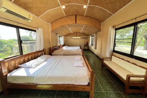 two beds in a room with windows at Rabiangmai Resort in Ban Ko Krang