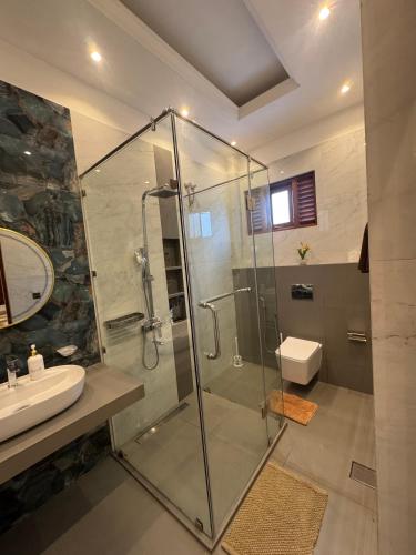 a bathroom with a glass shower and a sink at Ferien Villa in Kalutara