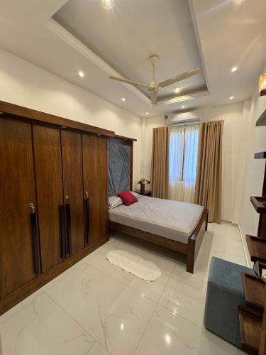 a bedroom with a bed and wooden cabinets at Ferien Villa in Kalutara