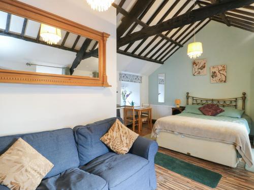 a living room with a blue couch and a bed at Fullers Studio in Holyhead