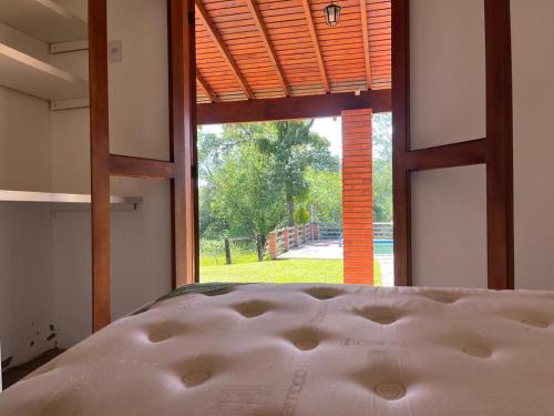 a bed in a room with a large window at Recanto do Sossego in Gravataí