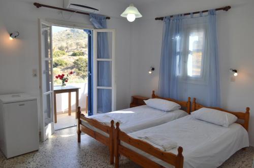 two beds in a room with a window at Koukos in Agia Theodoti