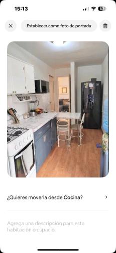a kitchen with a white stove and a table with chairs at Apartamento de 3 recámaras en el corazón de puebla in San Baltasar