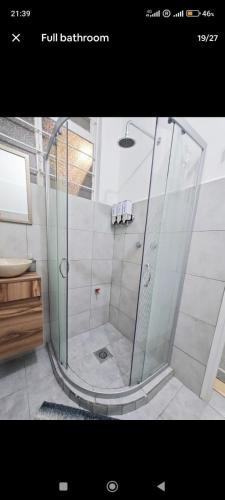 a shower with a glass door in a bathroom at Apartamento de 3 recámaras en el corazón de puebla in San Baltasar