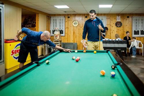 two men playing a game of sn pool at Villaggio Turistico Camping Cervino in Antey-Saint-André