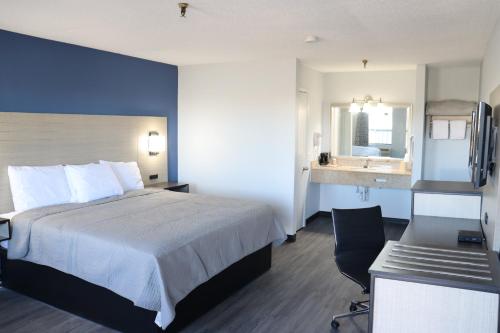 a hotel room with a bed and a desk and a sink at legacy inn paducah in Paducah