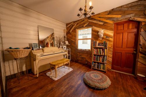 a room with a piano and a book shelf at Creatives Retreat for Artists & Lovers in Gainesville