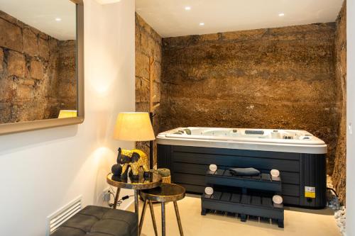 a bathroom with a tub and a chair and a table at AC Encanto in La Cisnera