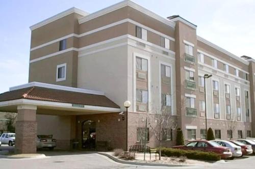 a large building with cars parked in a parking lot at Wesley Inn and Suites in Wichita
