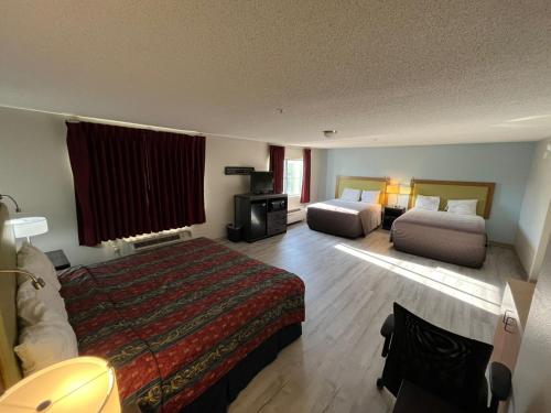 a hotel room with two beds and a television at Wesley Inn and Suites in Wichita