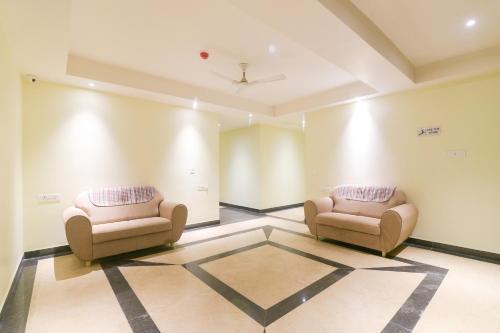 two chairs sitting in a room with a wall at Super OYO 77736 Hotel Starlight in Kānpur