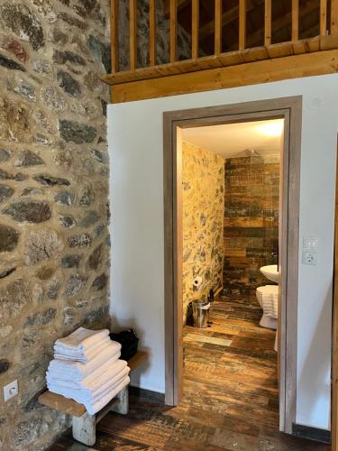 a doorway to a bathroom with a stone wall at Konstantina 2 in Ayía Varvára